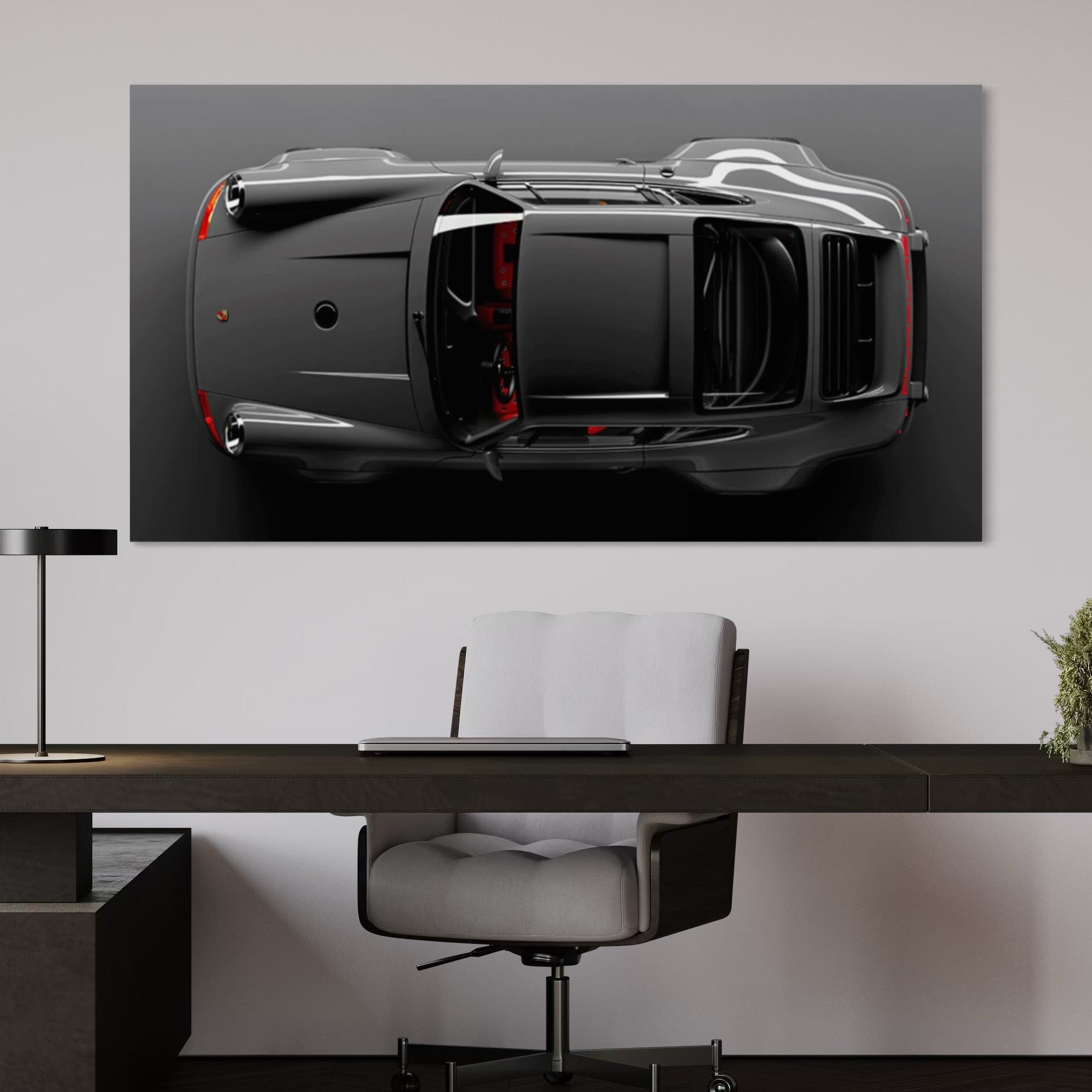 Car artwork on a wall above a desk with a chair.