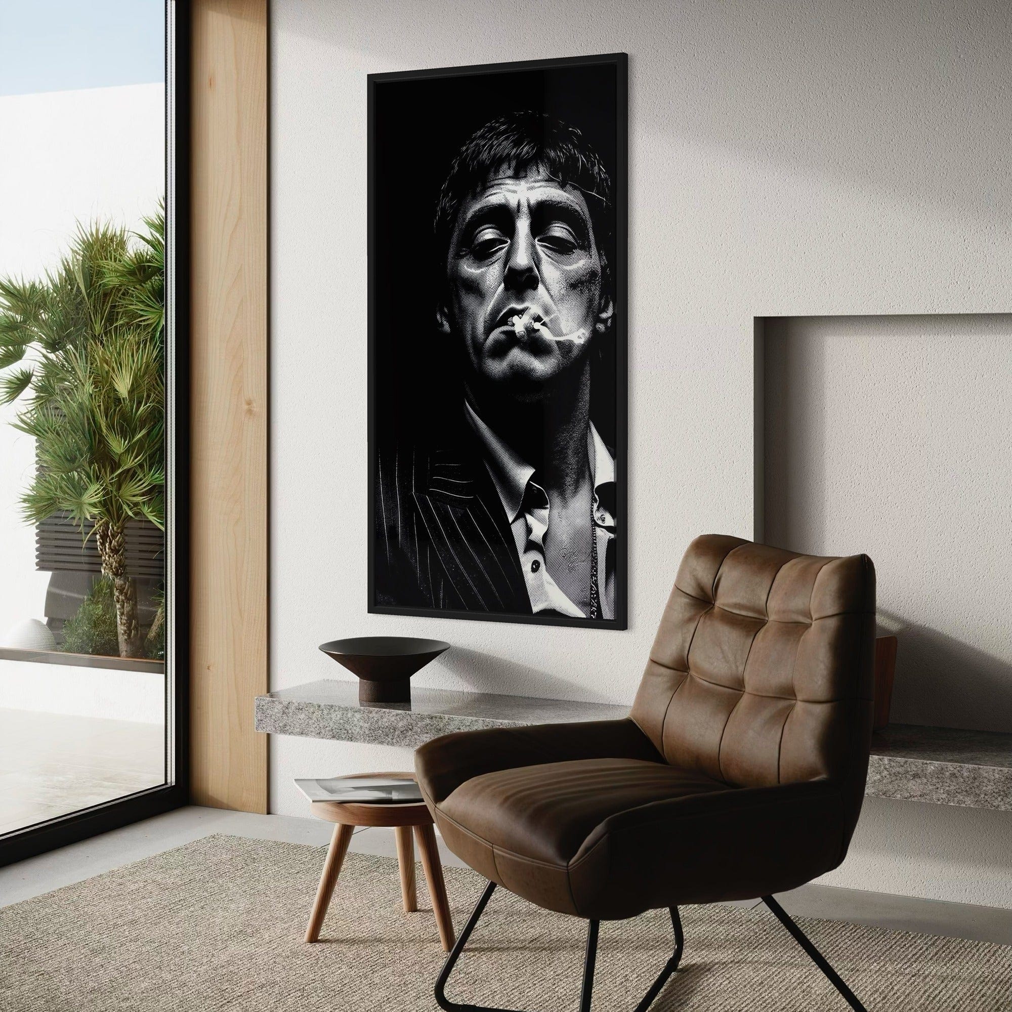 Modern interior with a large framed portrait of a man on the wall, a brown leather chair, and a small table.