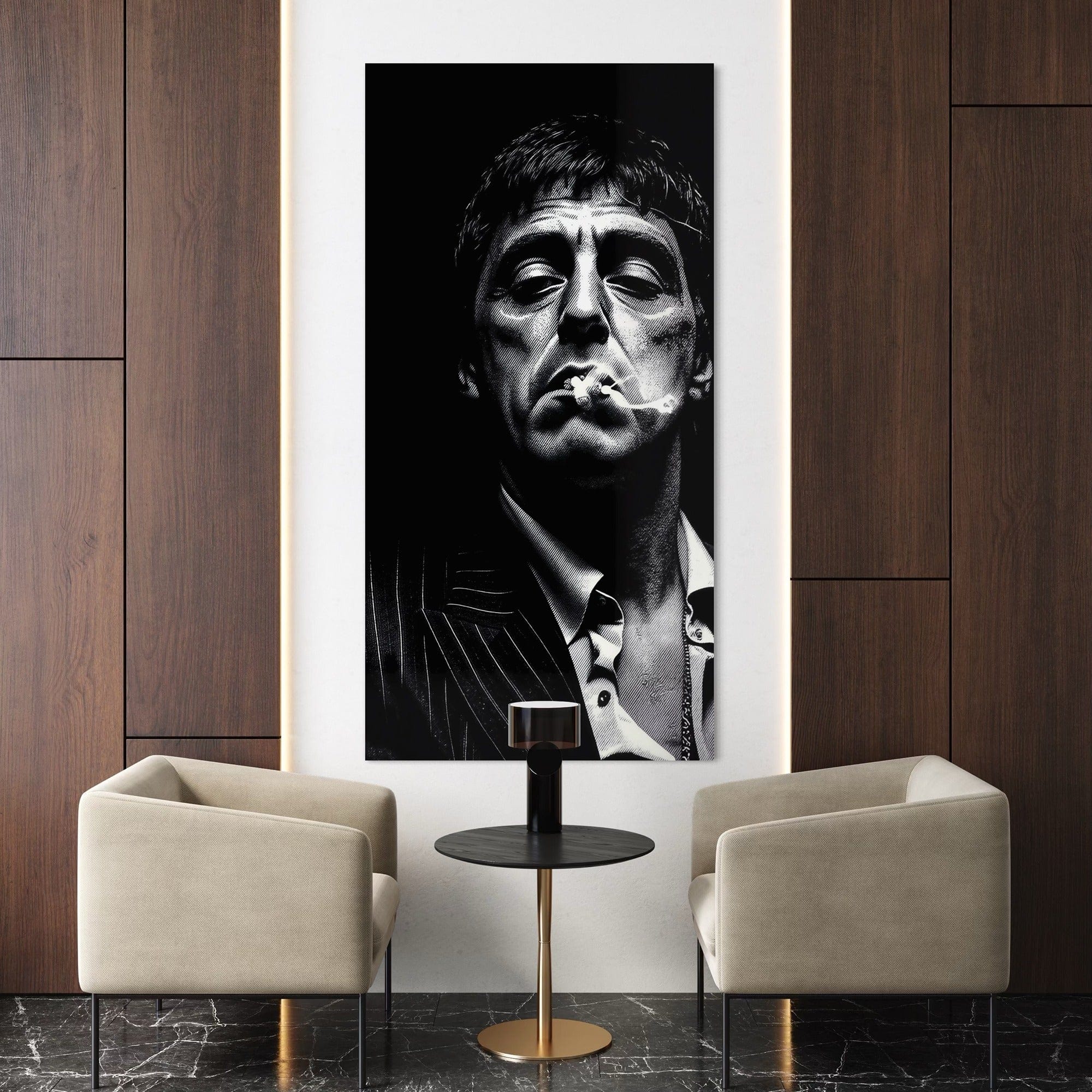 Large black and white portrait of a man smoking on a wall above two beige armchairs and a small round table.