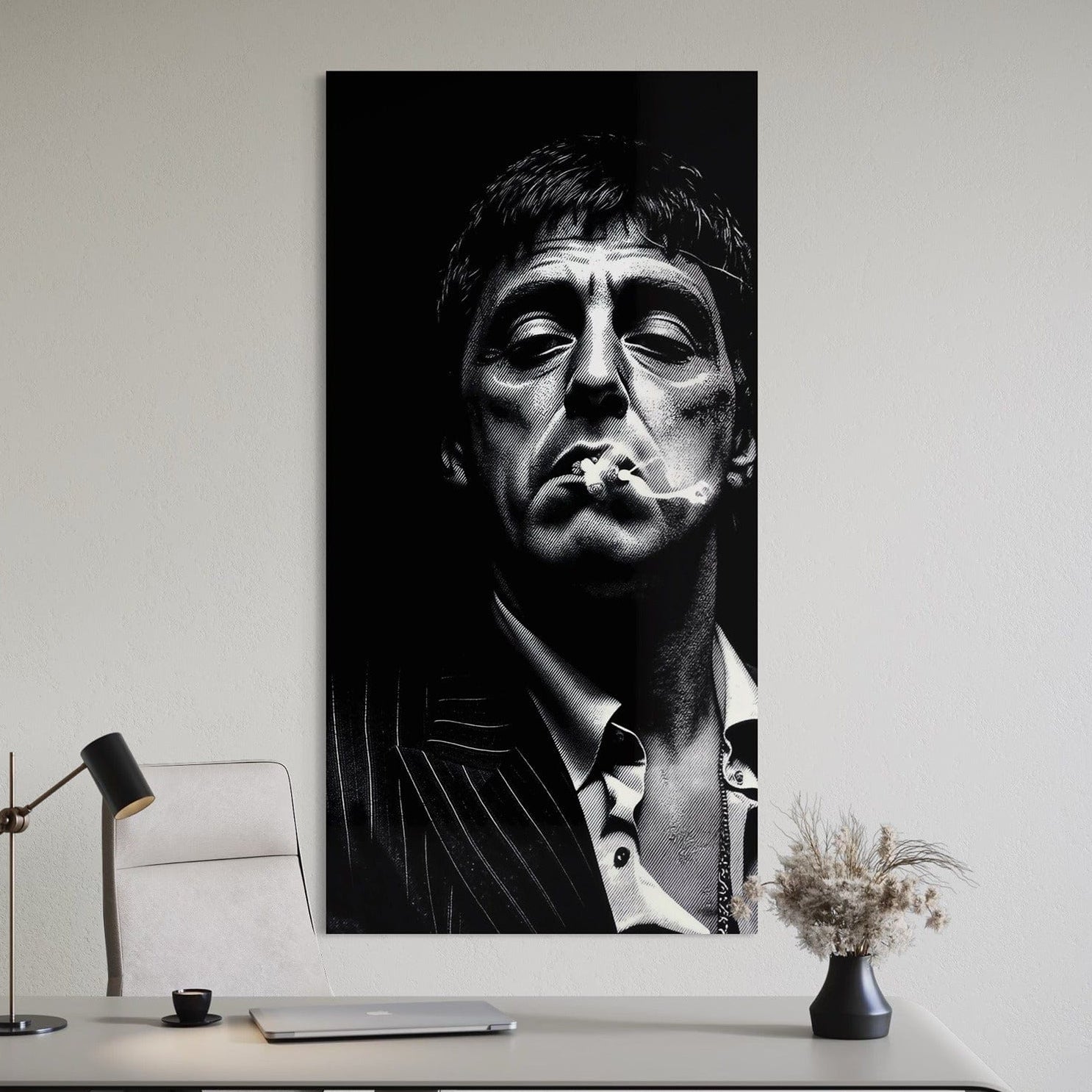 Black and white portrait of a man smoking on a wall above a desk.