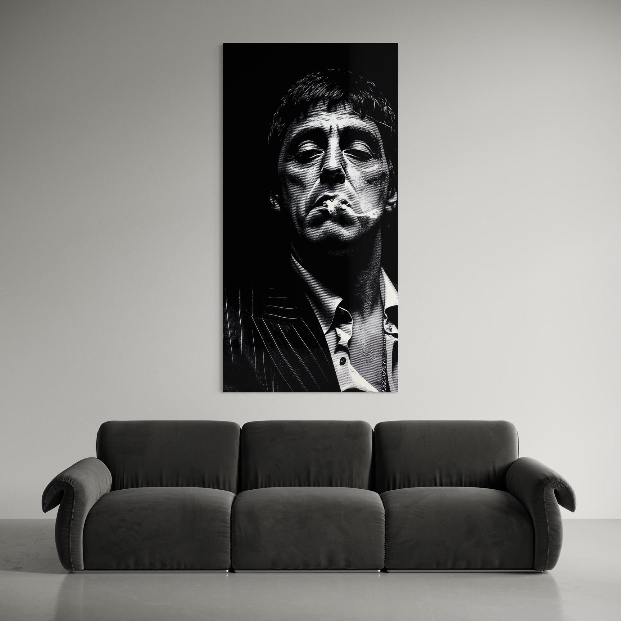 Black and white portrait of a man smoking above a gray sofa.