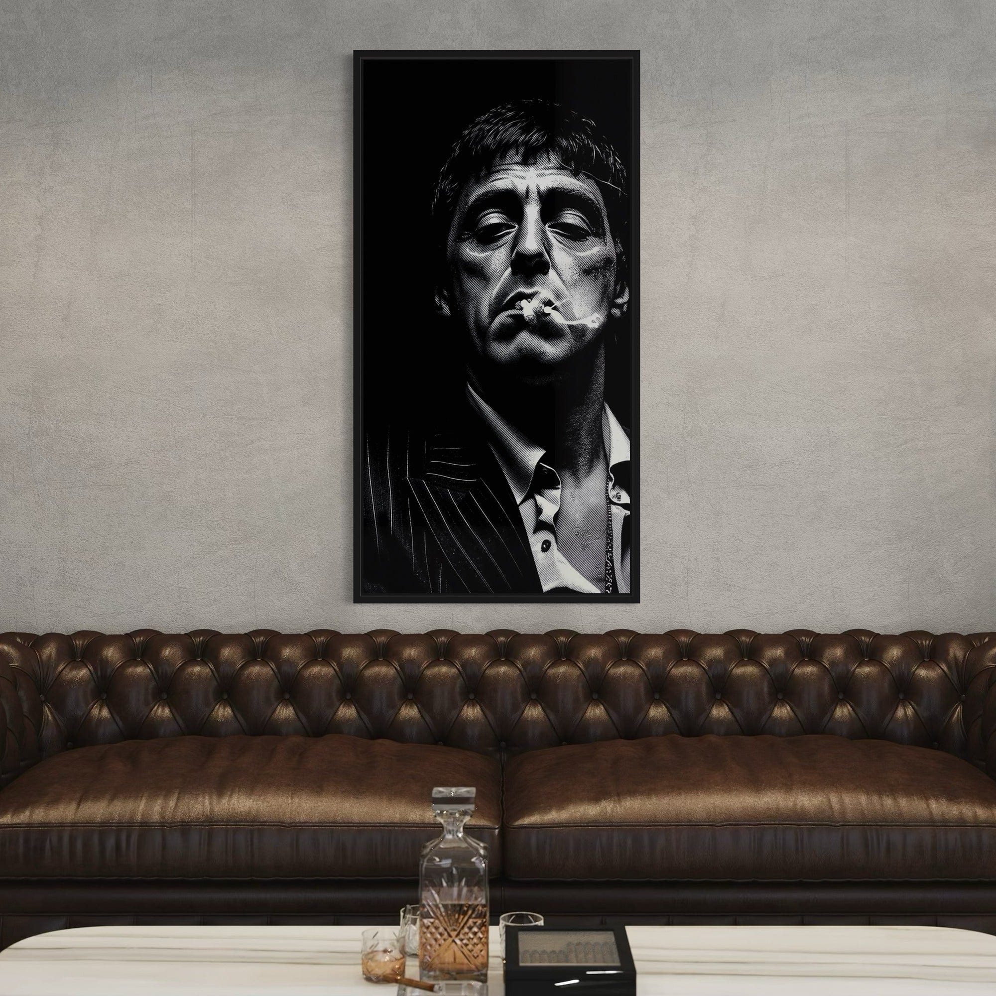 Framed black and white portrait of a man smoking above a brown leather sofa.