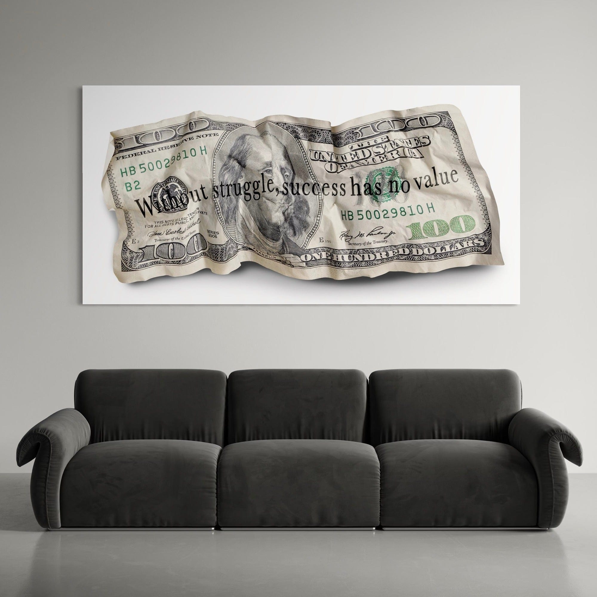 Canvas print of a crumpled dollar bill with text above a black sofa.