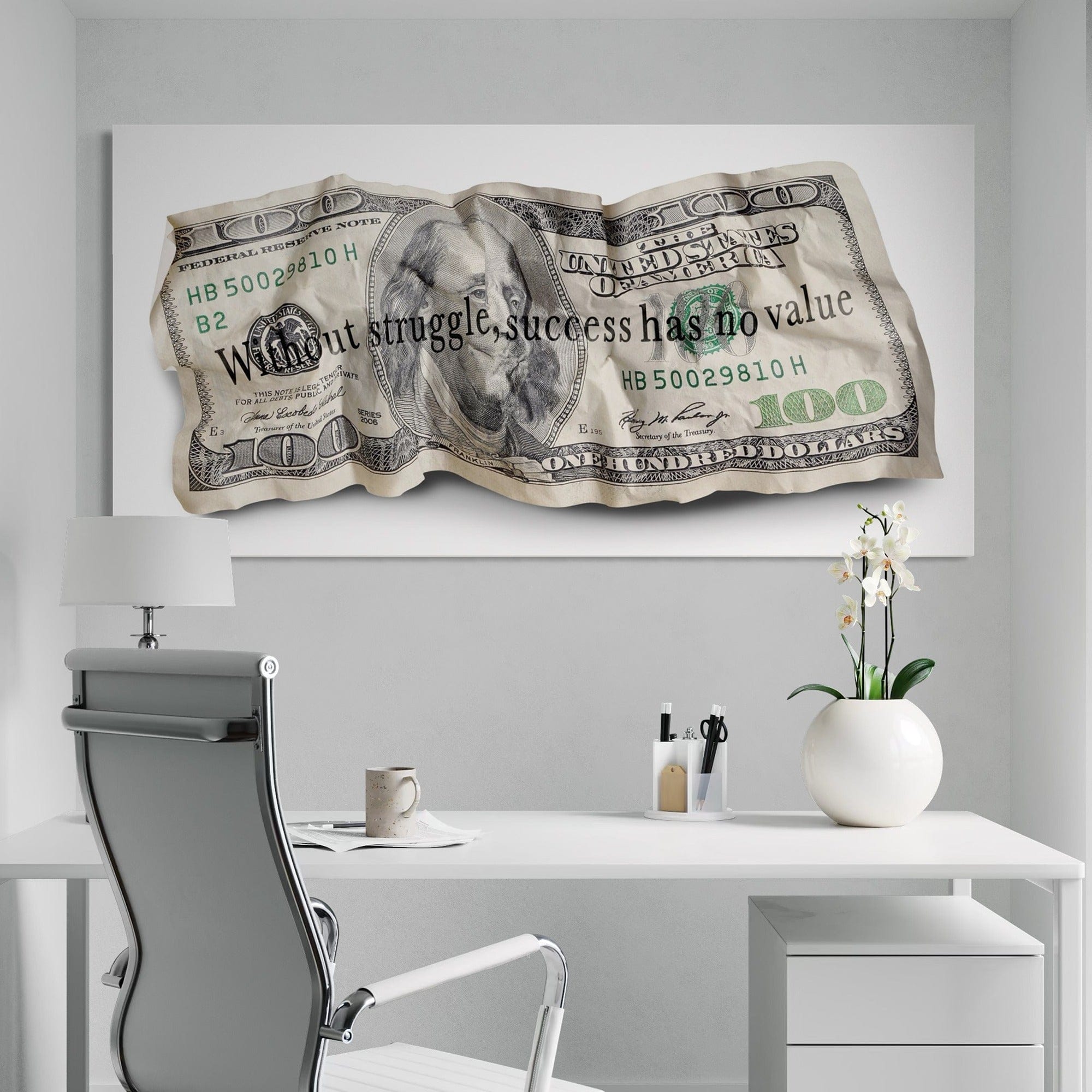 Decorative wall art of a crumpled dollar bill with text in an office setting.